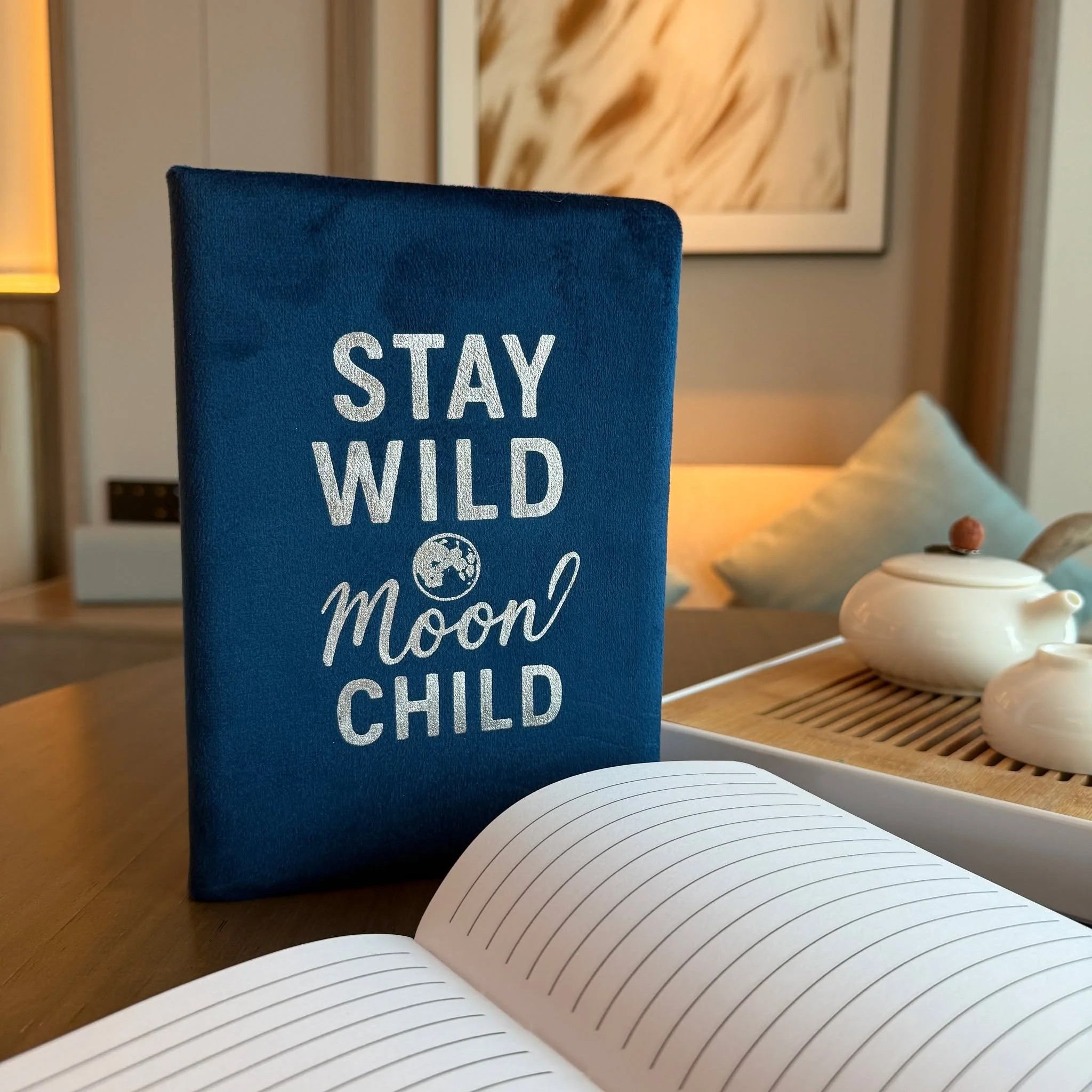 Let your imagination wander under the stars with this dark blue velvet notebook, embossed with the words &ldquo;Stay Wild Moon Child.&rdquo; Its soft, plush cover and shimmering silver design make it both inspiring and stylish.

Featuring 80 lined pa