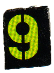 Close-up of a black rectangular patch with a bright yellow number 9 displayed.