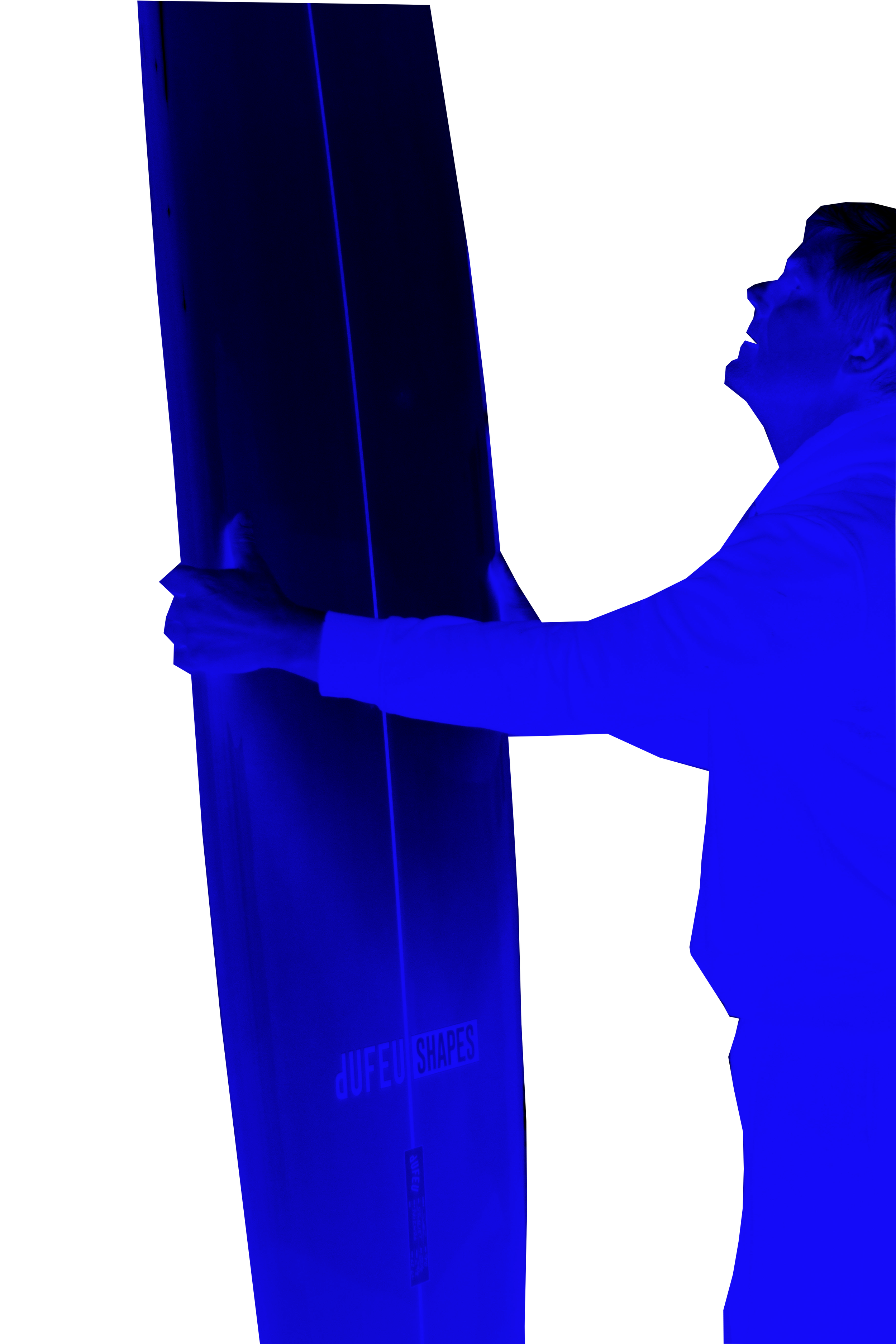 A man in a white shirt pushing or holding a large vertical display panel with the text 'dUfEU SHAPES' at the bottom, illuminated with blue lighting.