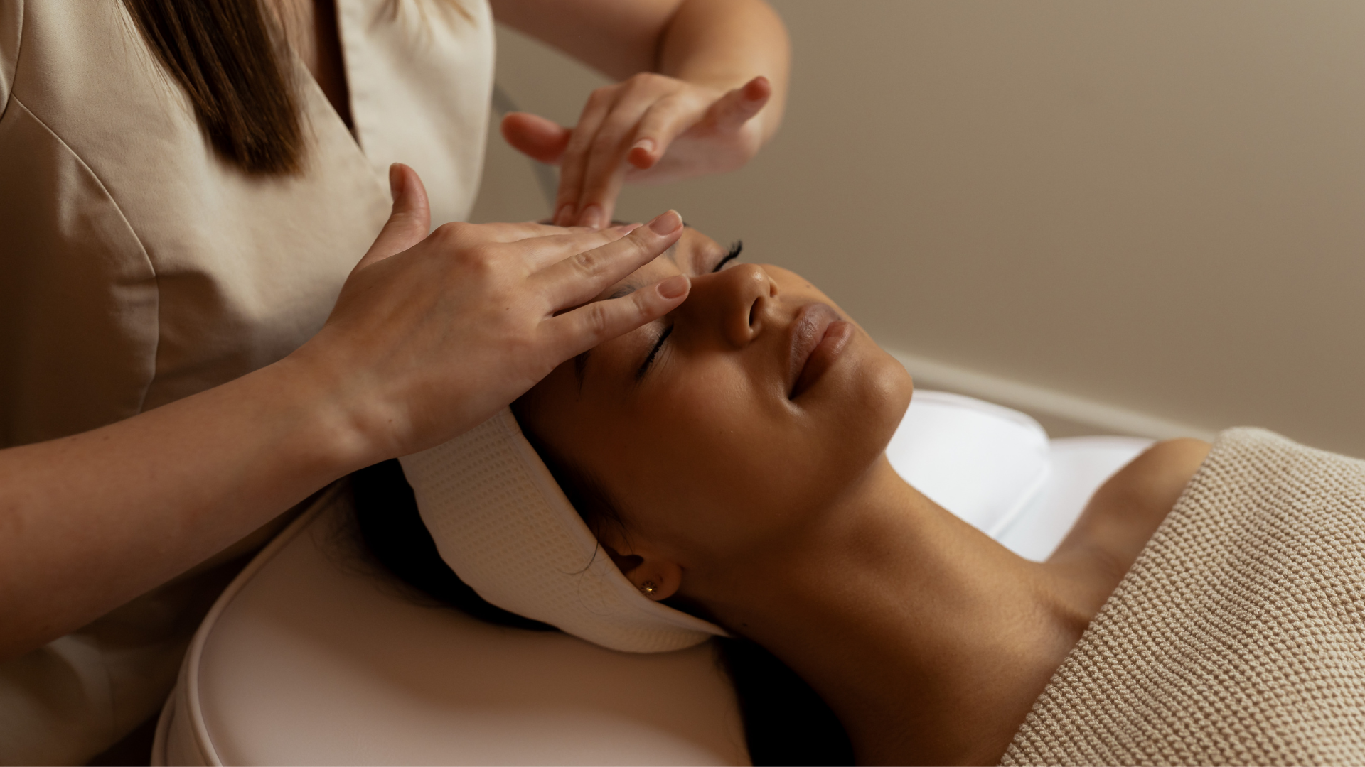 Mujer recibiendo un masaje facial en un spa.