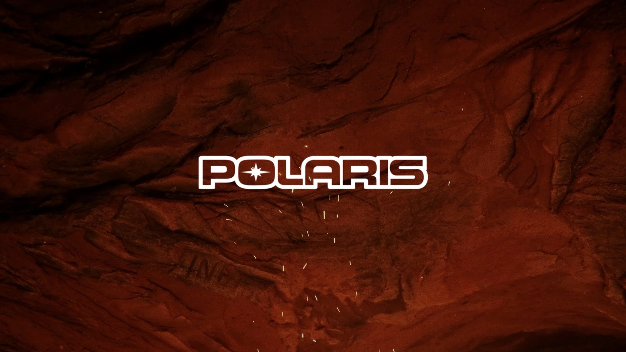 Inside a red rock formation or cave with the word POLLARIS and a star symbol in the center in white, modern font.