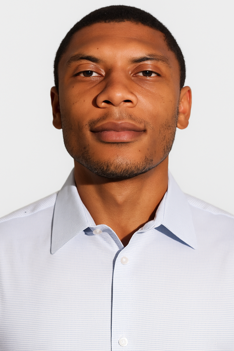 Headshot of a young man with short black hair, wearing a light blue collared shirt, looking confidently at the camera against a plain white background.