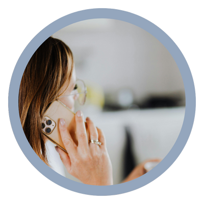 Person talking on a landline phone, viewed through a circular mirror
