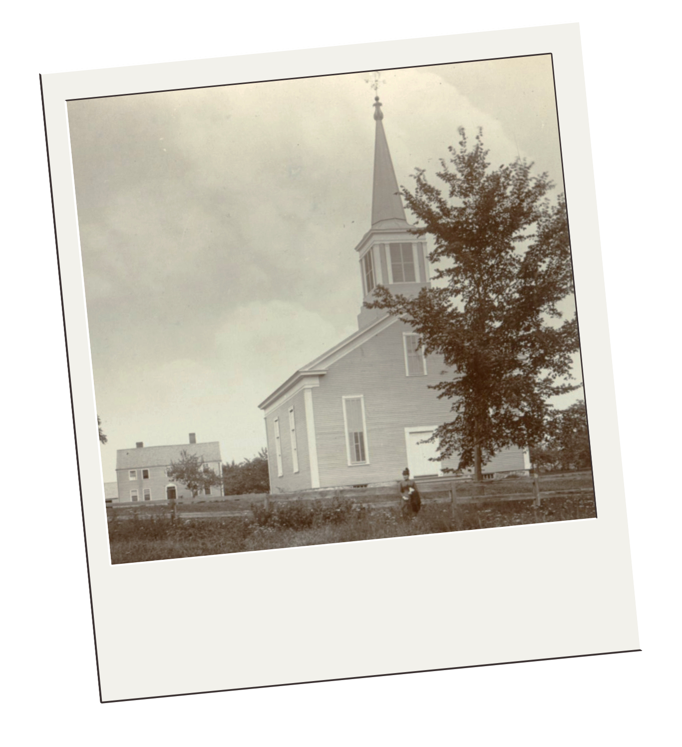 Black and white photo of a church with a tall steeple and a person standing outdoors near trees.