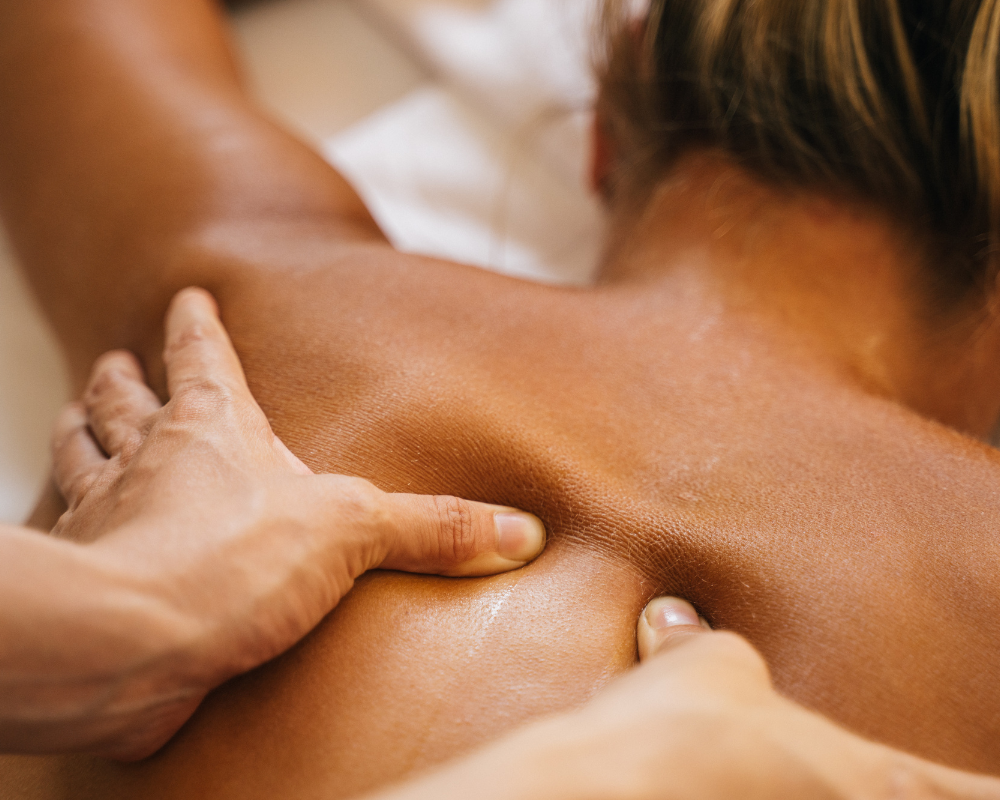 A person receiving a massage on their back from a massage therapist.