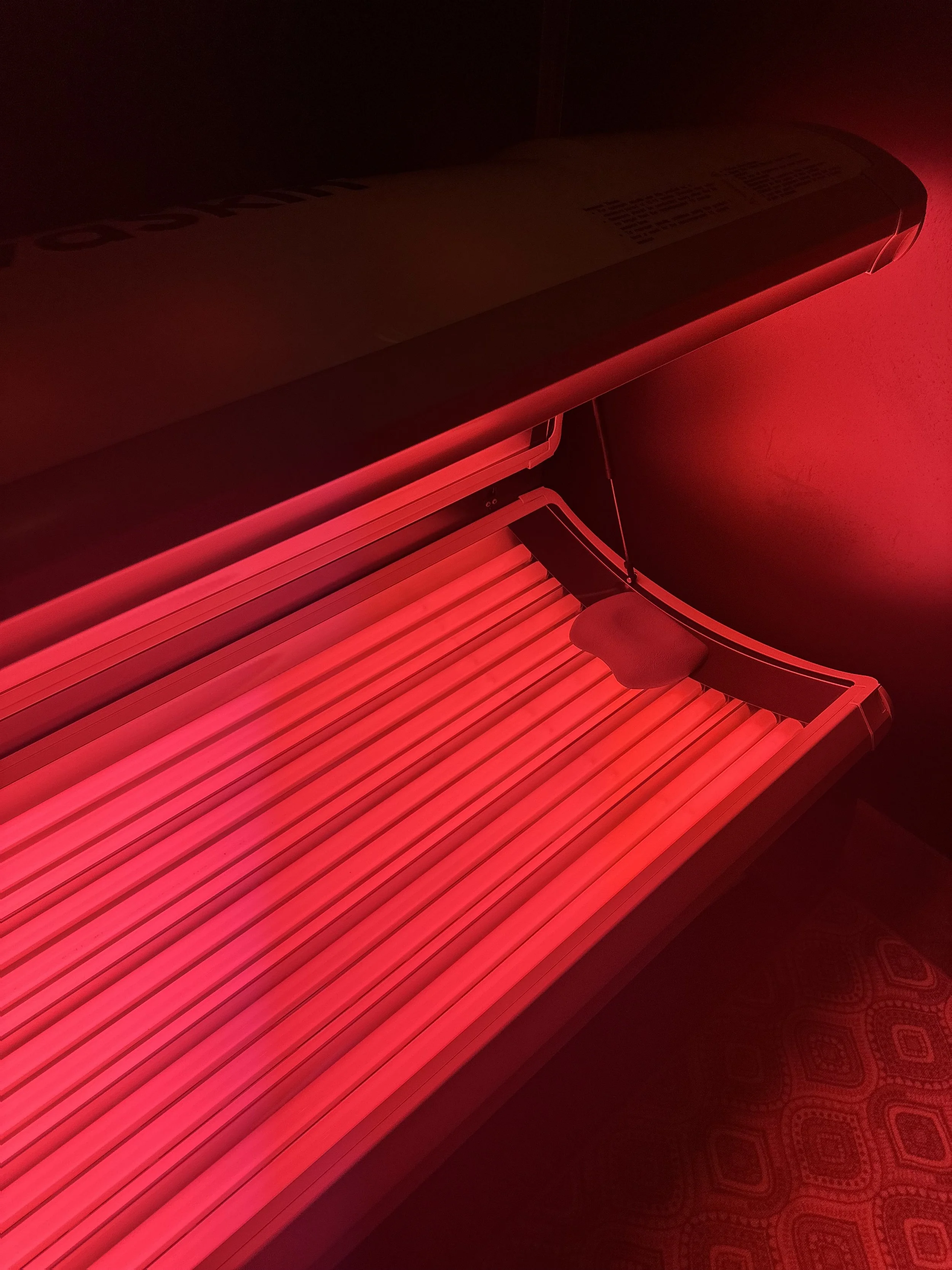 A tanning bed emitting bright pink light.