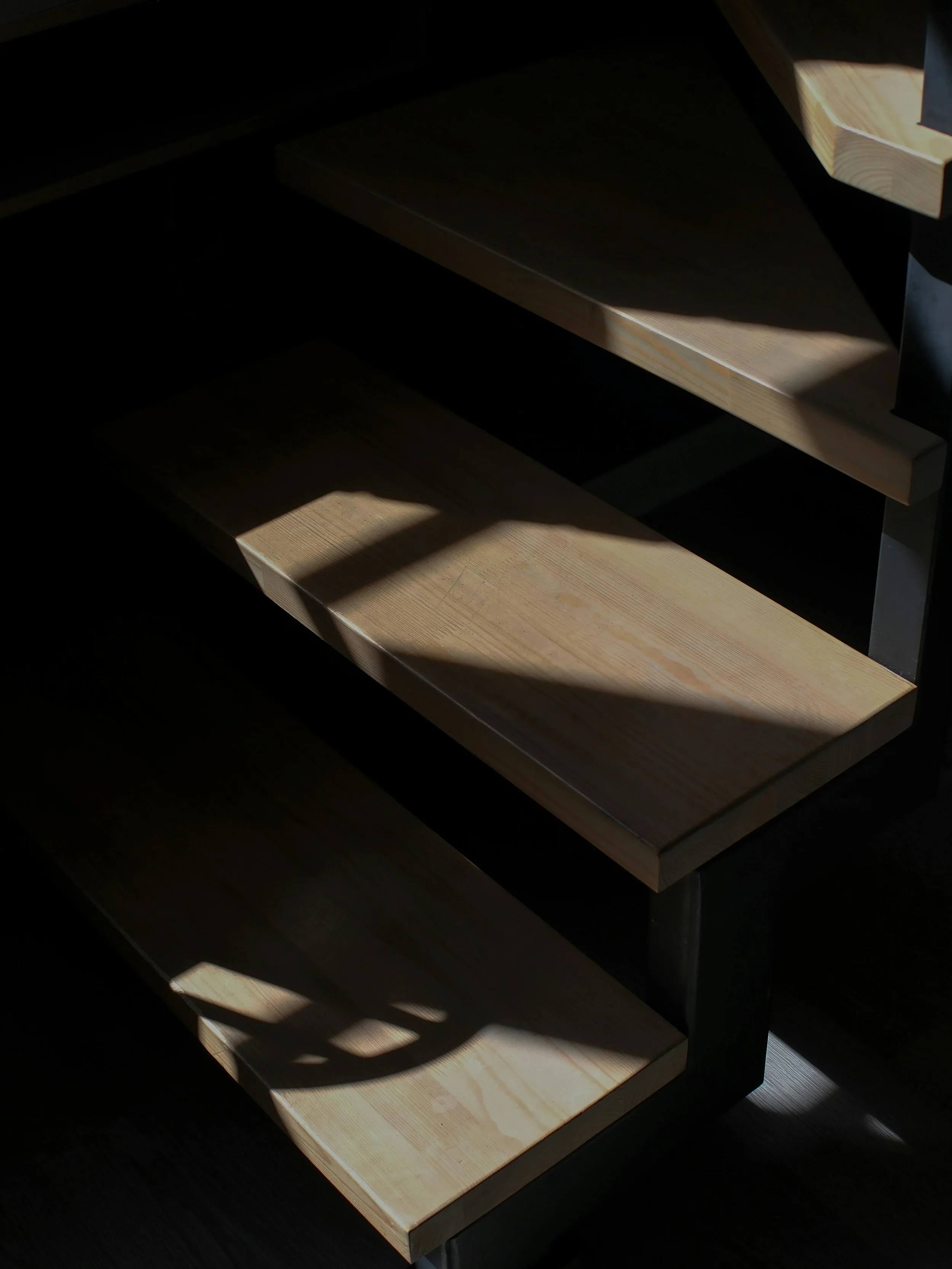 Wooden stair steps with light and shadow patterns on each step