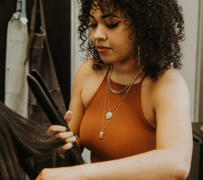 Ya Girl with the Curl using a straightener on a client.