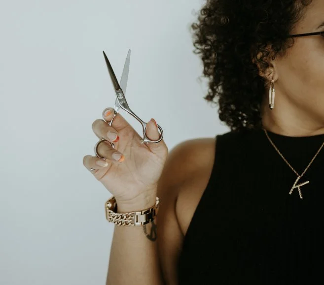 Ya Girl with the Curl holding her scissors. 