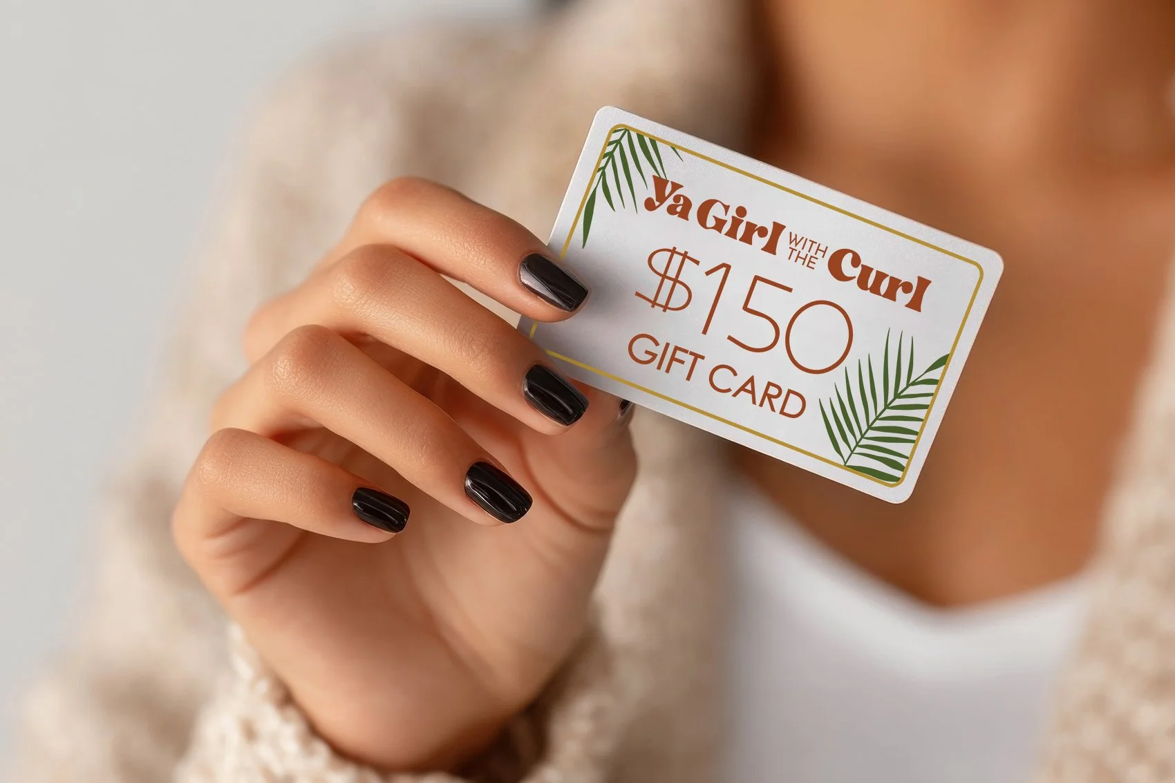 A photo of a hand holding a gift card for services at Ya Girl With the Curl.