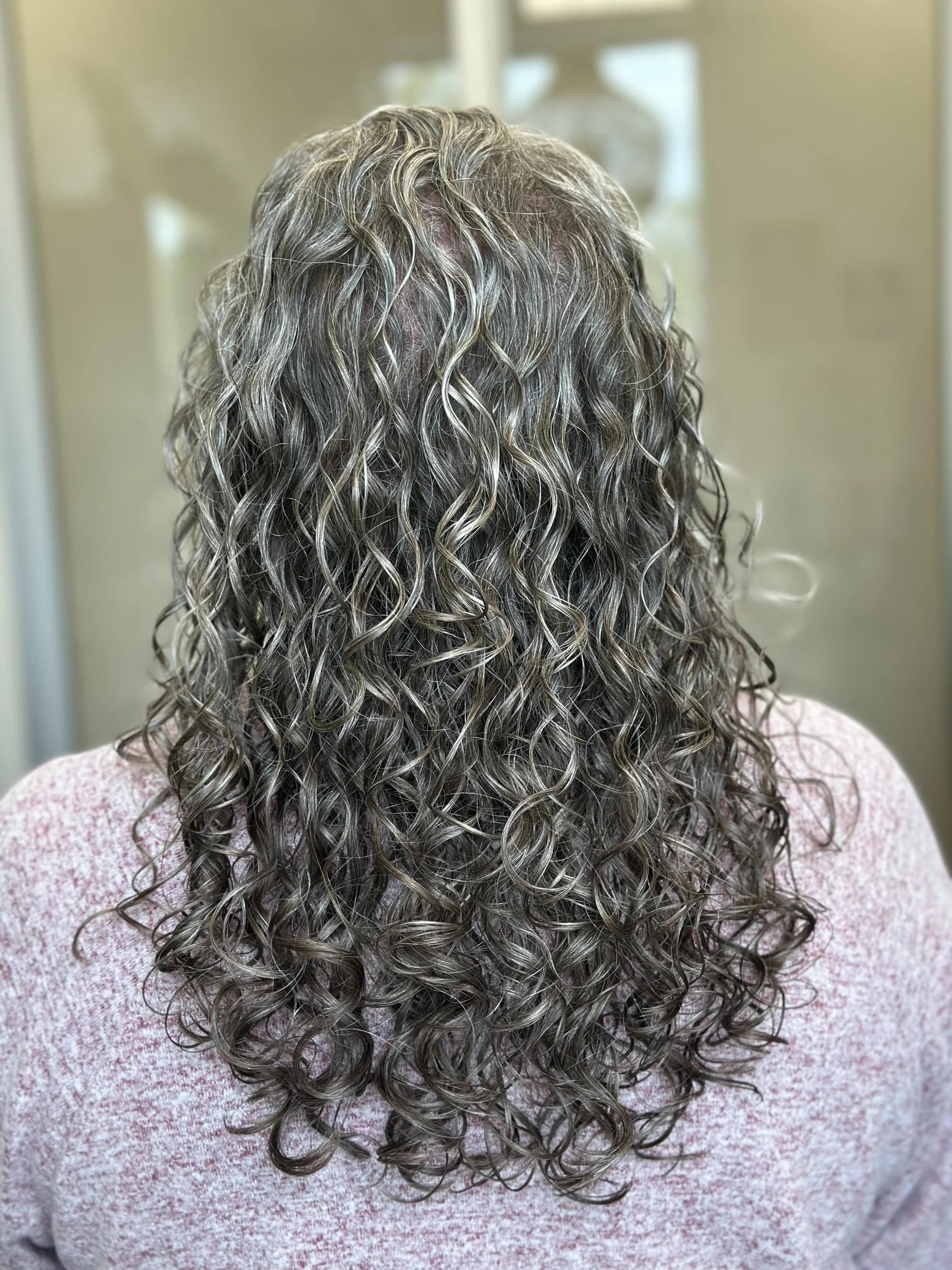 Photo of a client with long, healthy curls.