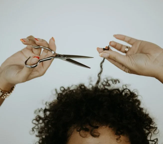 A curly client getting their curls trimmed.