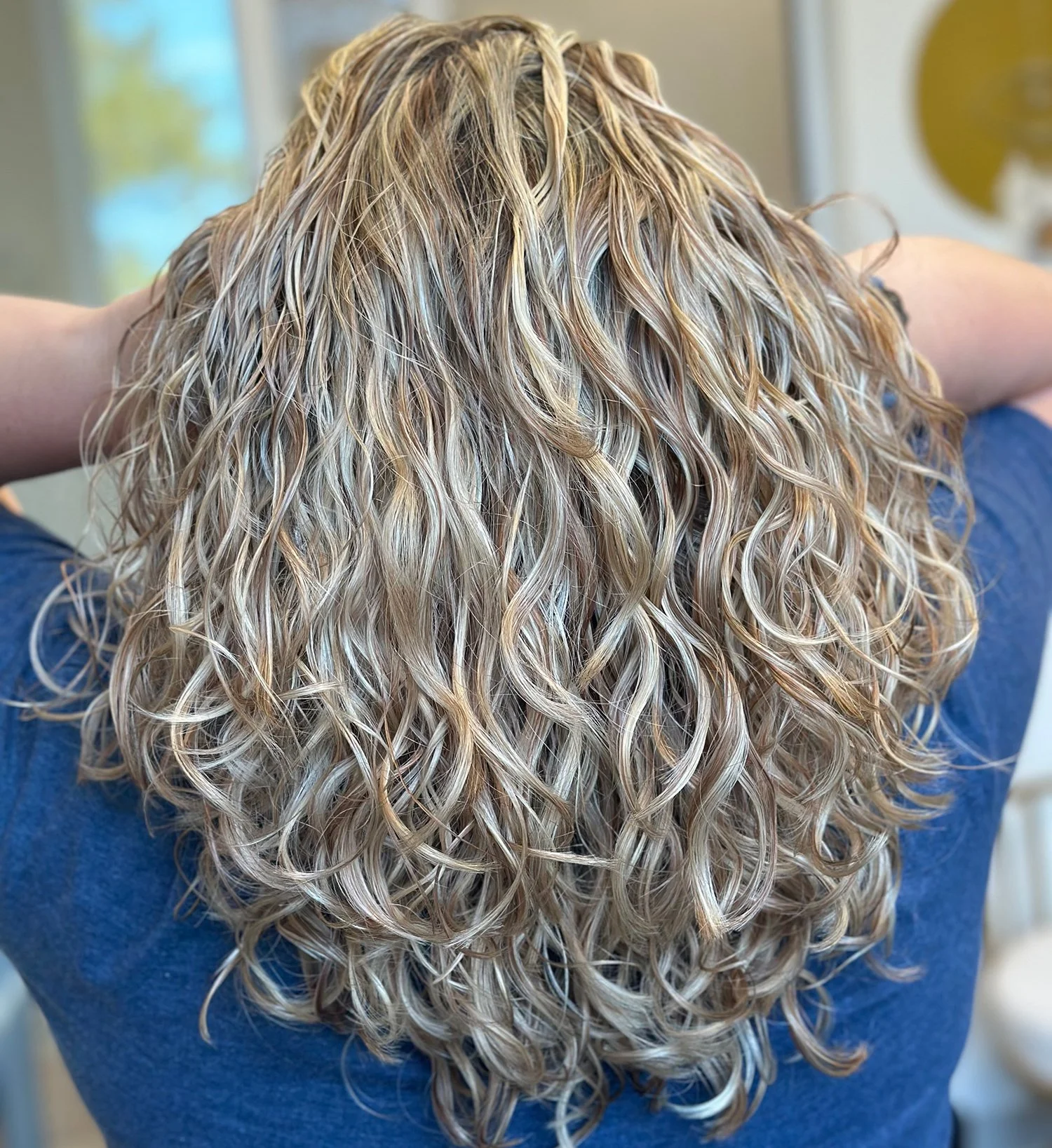 A close-up photo of the back of a client's hair showing the vibrant and dimensional results of a full foil.