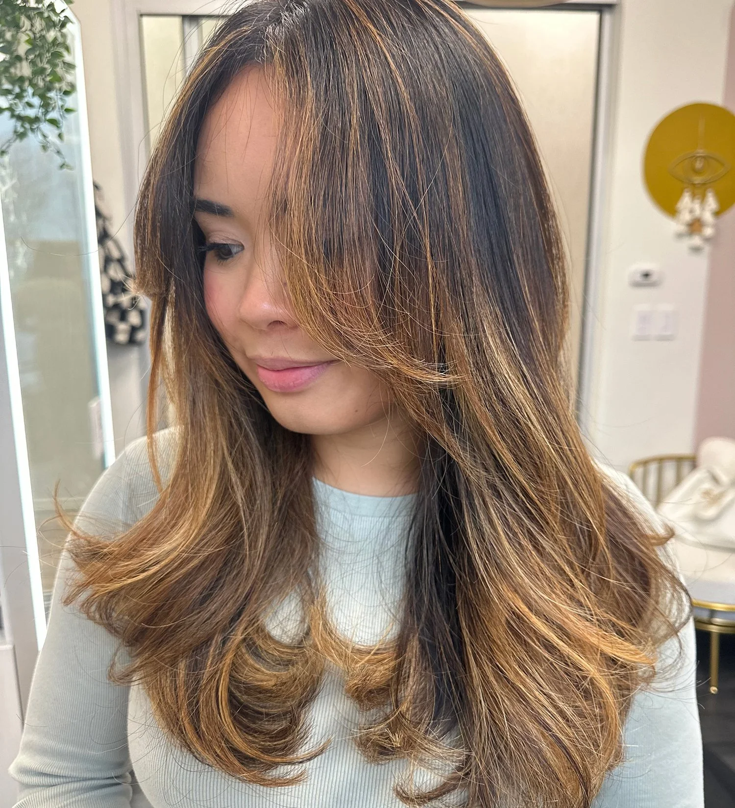 A close-up of a client with a dark brown to blond balayage service.