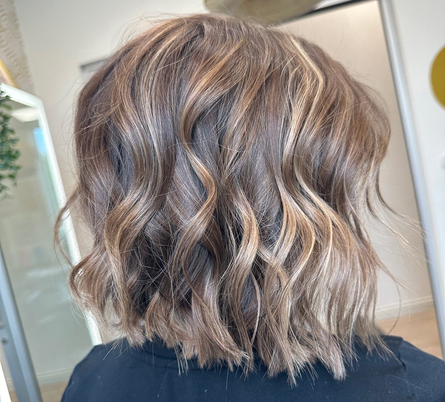 A photo of a fun blond bob with a wave style and lots of dimension.