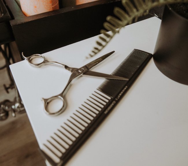 A close-up shot of a pair of cutting shears with a comb.