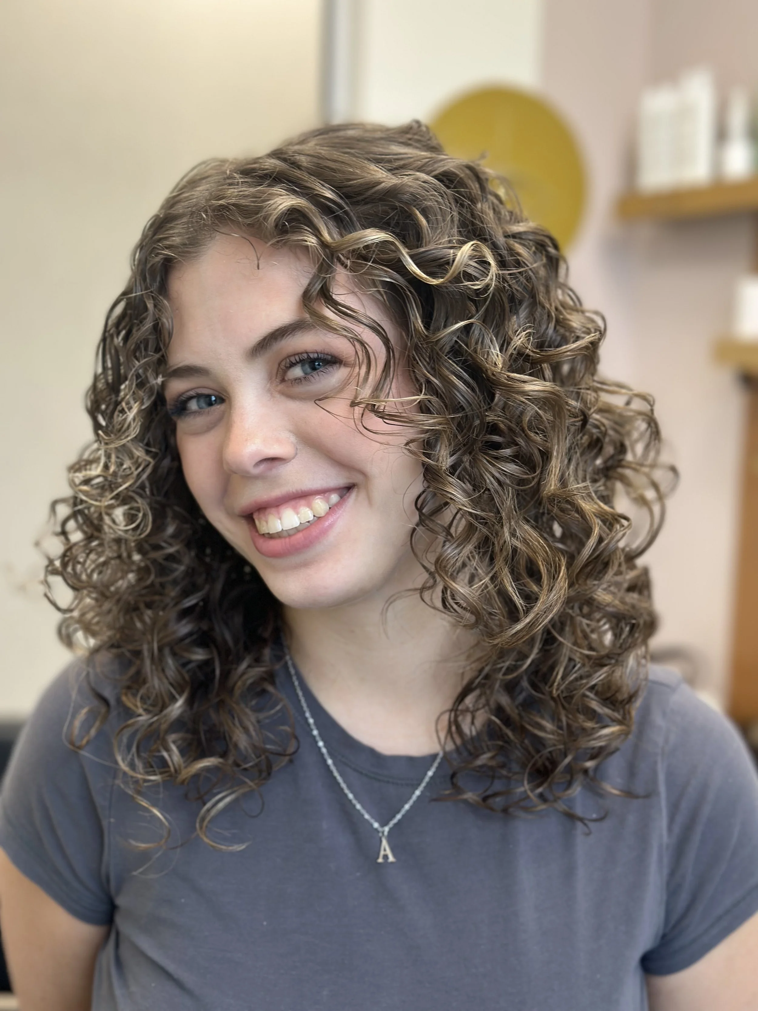 Photo of a happy client with healthy curls.