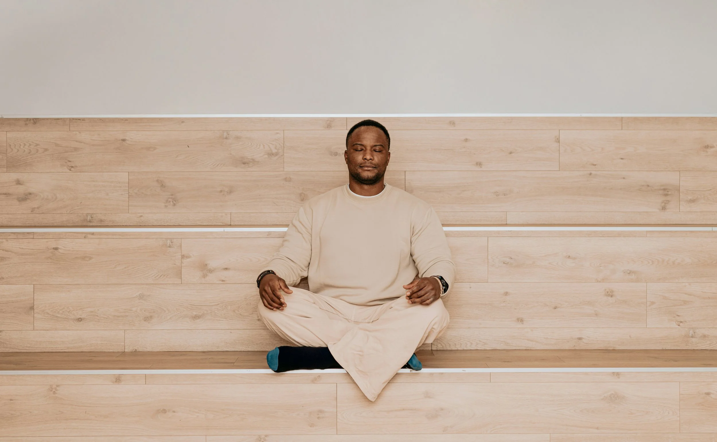 Man seated cross-legged with eyes closed, practicing stillness and ending suppression