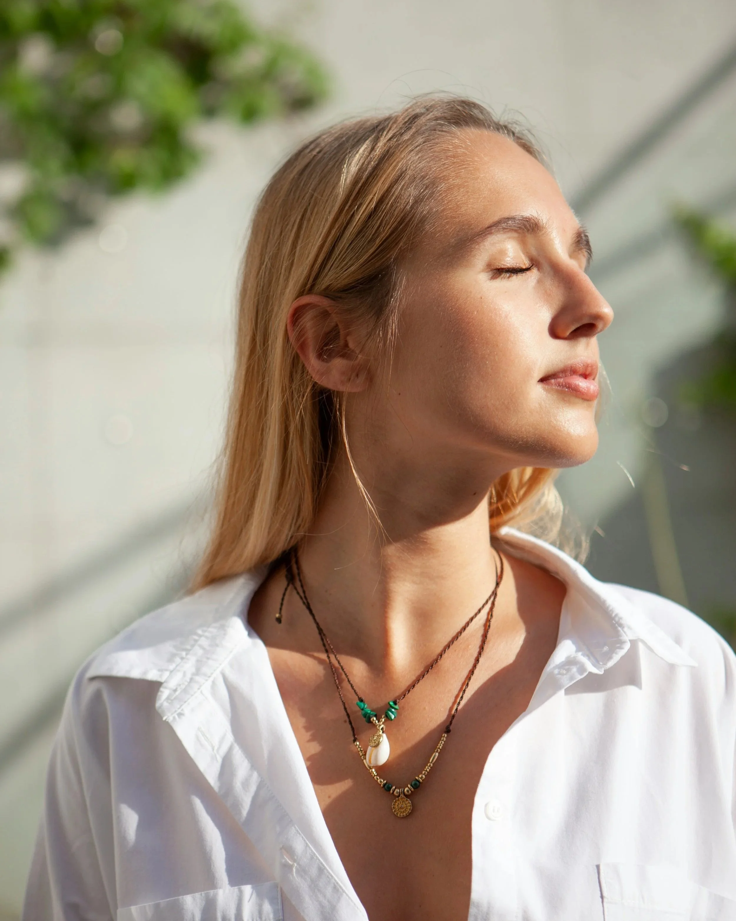Woman with eyes closed tilting face upward in sunlight, embodying the self-loyalty framework