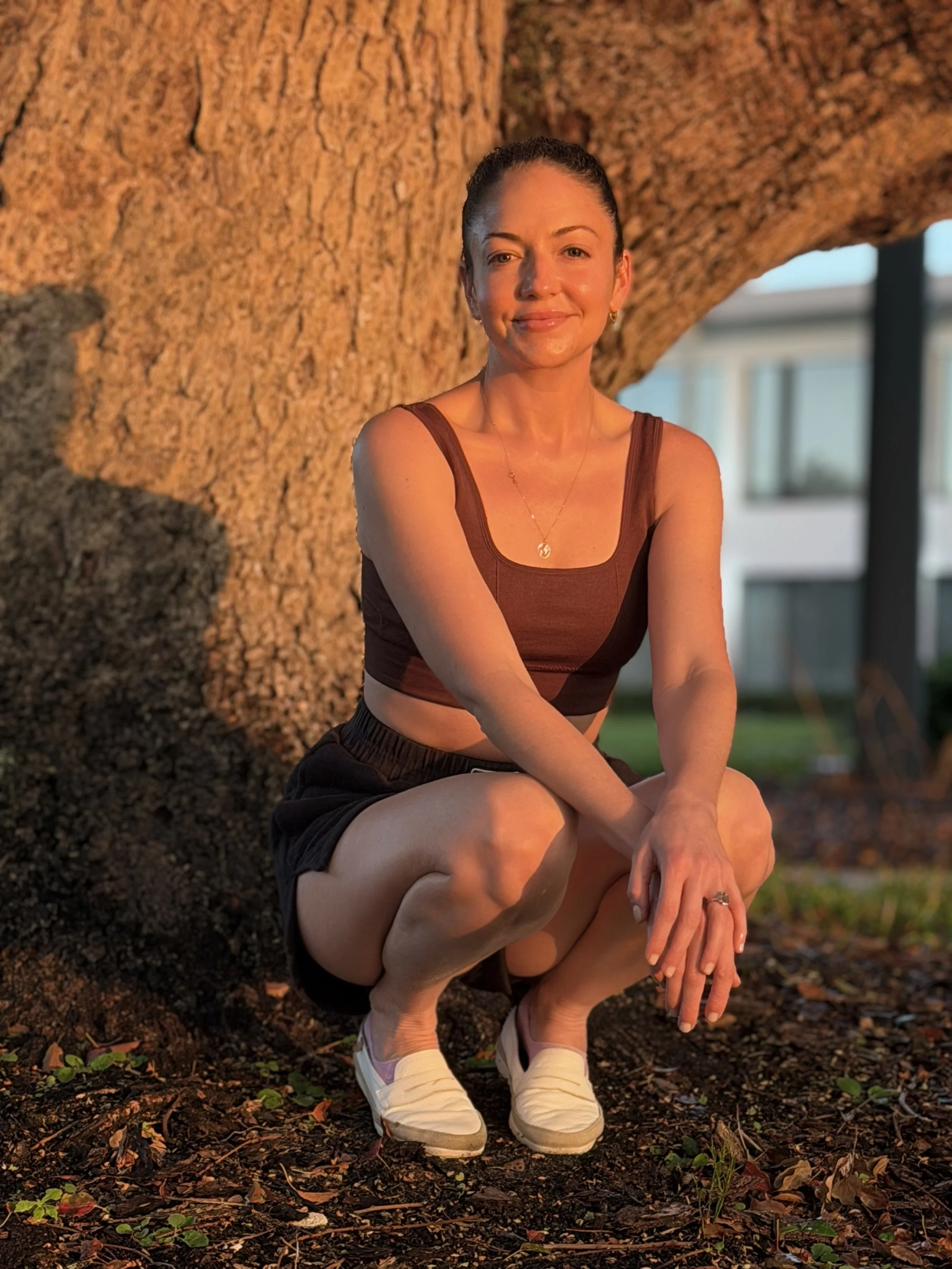Priscilla Zorrilla holistic coach and yoga teacher seated outdoors in warm golden light