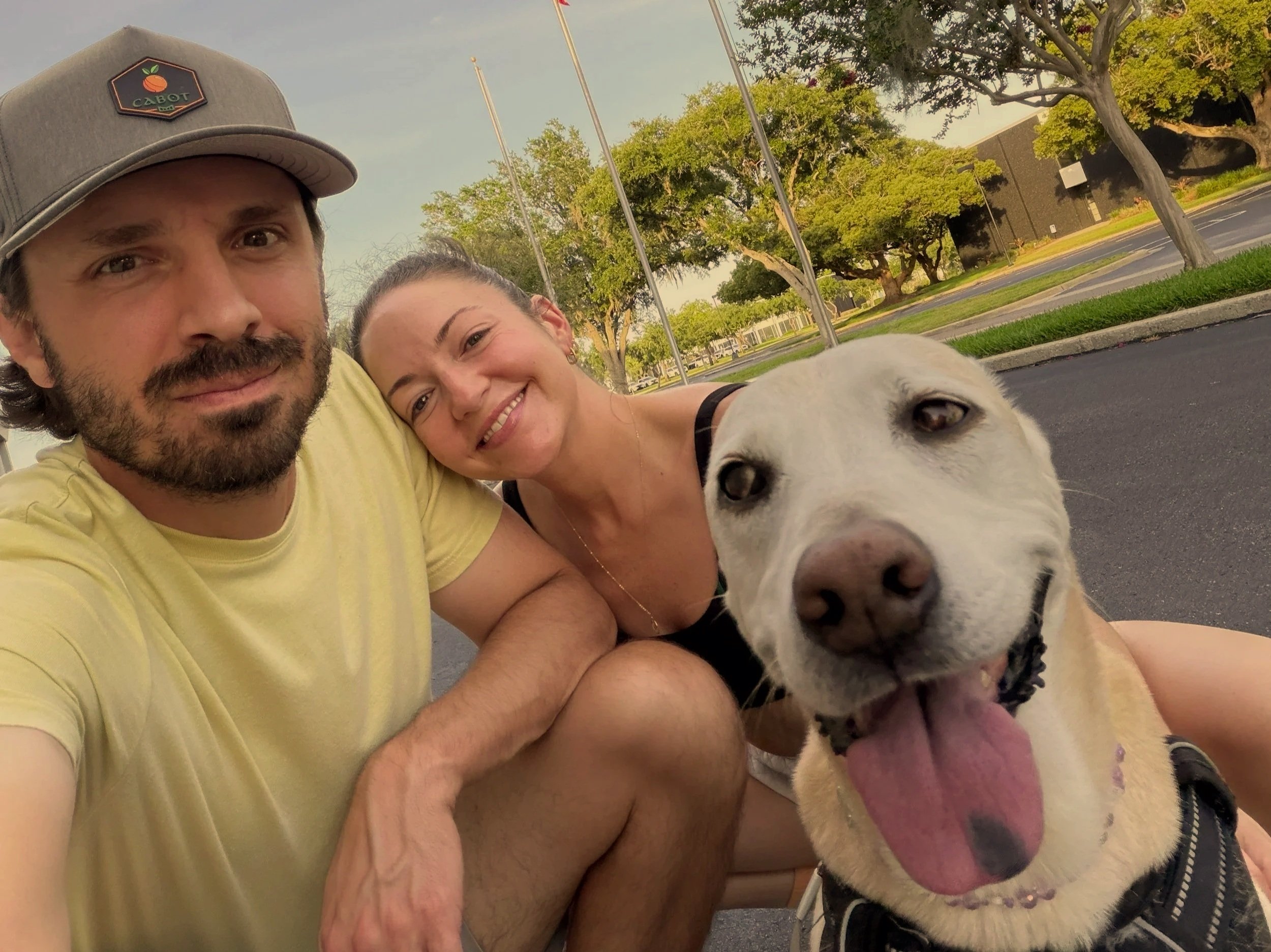 Priscilla Zorrilla with her fiancé and dog outdoors smiling, representing the evolution from rigid self-protection to compassionate self-loyalty and choosing what is best for us
