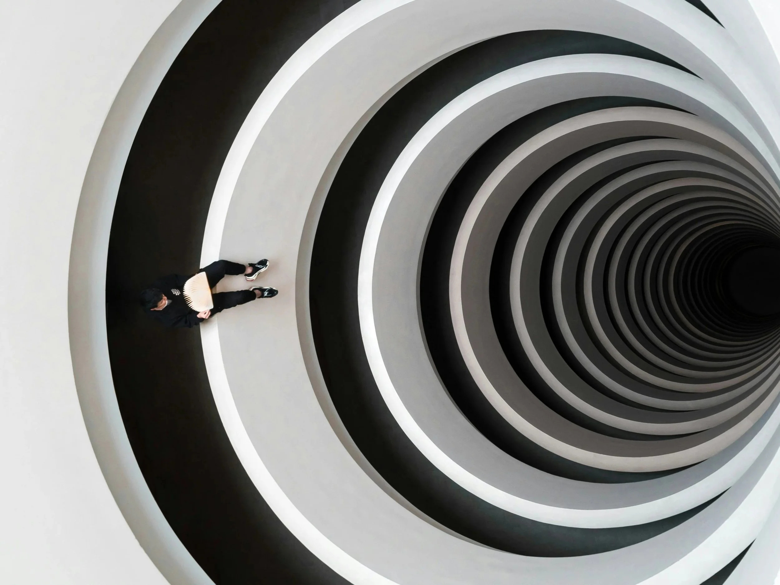 Aerial view of a person standing inside a black and white spiral, depicting circular thinking