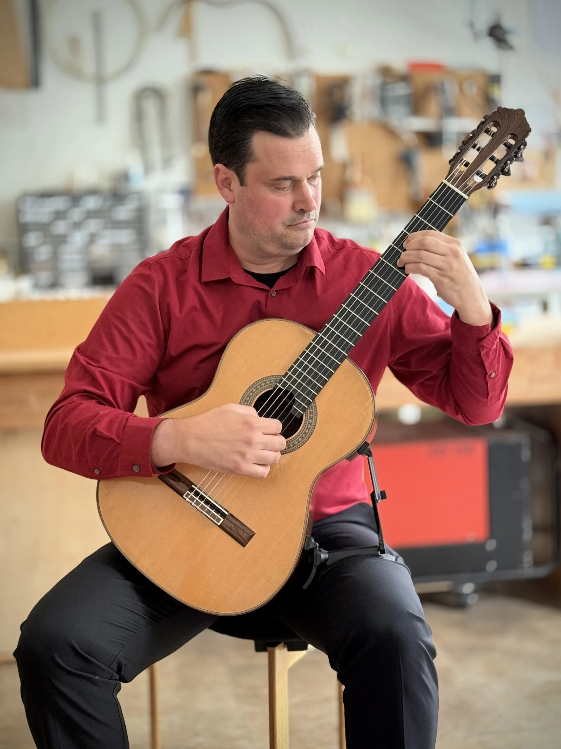 Anthony DeMers performing classical guitar in his Pacific Grove studio