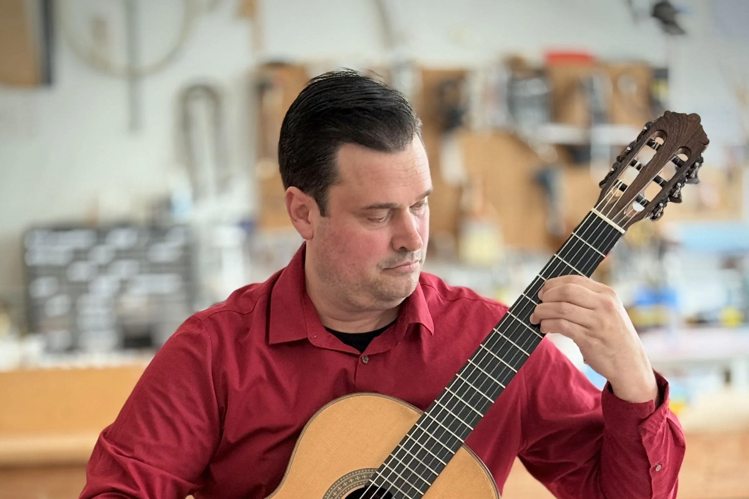 Anthony DeMers performing classical guitar in his Pacific Grove studio