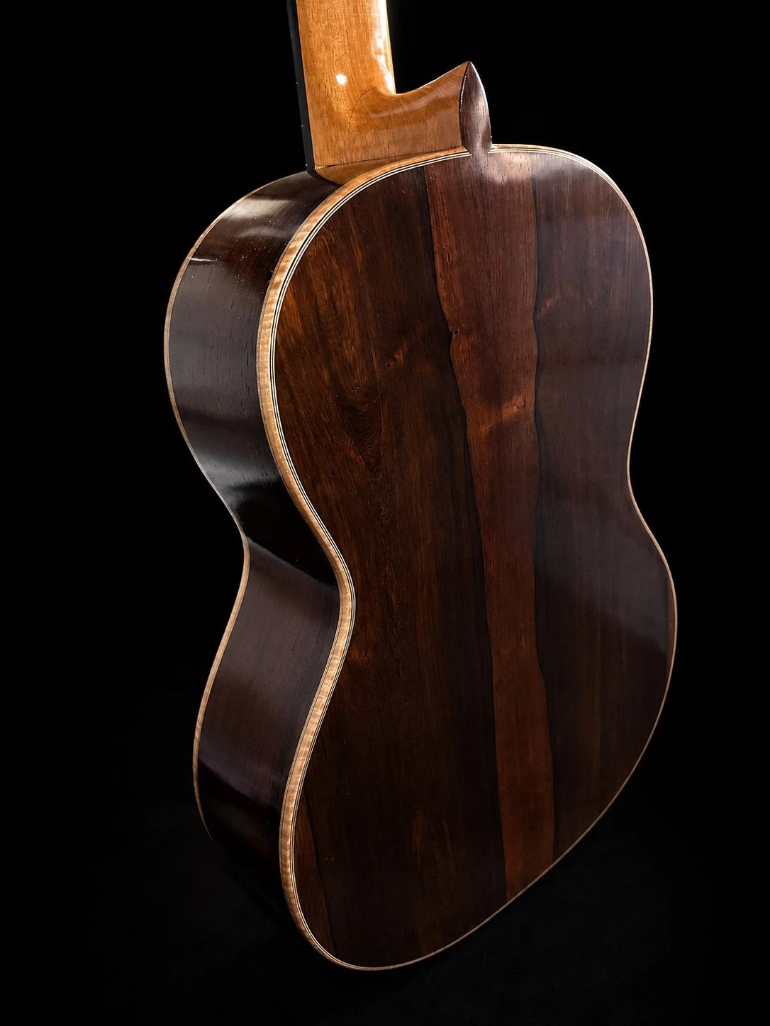 Rear studio view of DeMers Guitar No. 18, showing its three-piece back, sculpted heel, figured binding, and dark rosewood sides