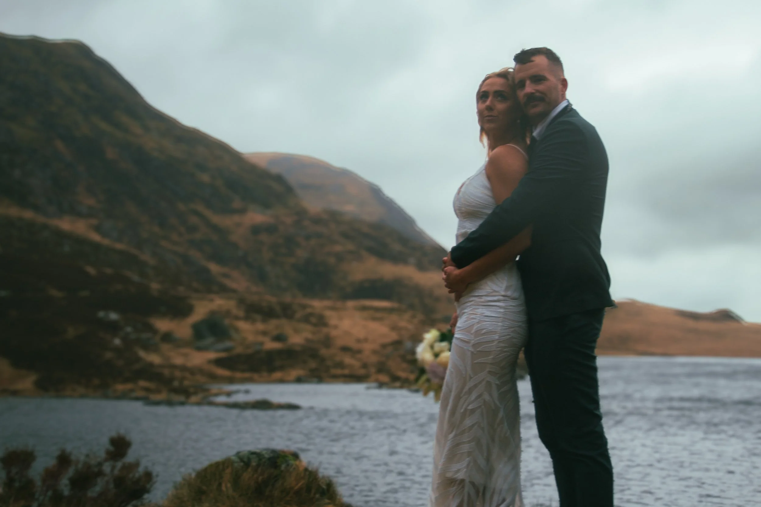 A couple embracing beside a mountain lake
