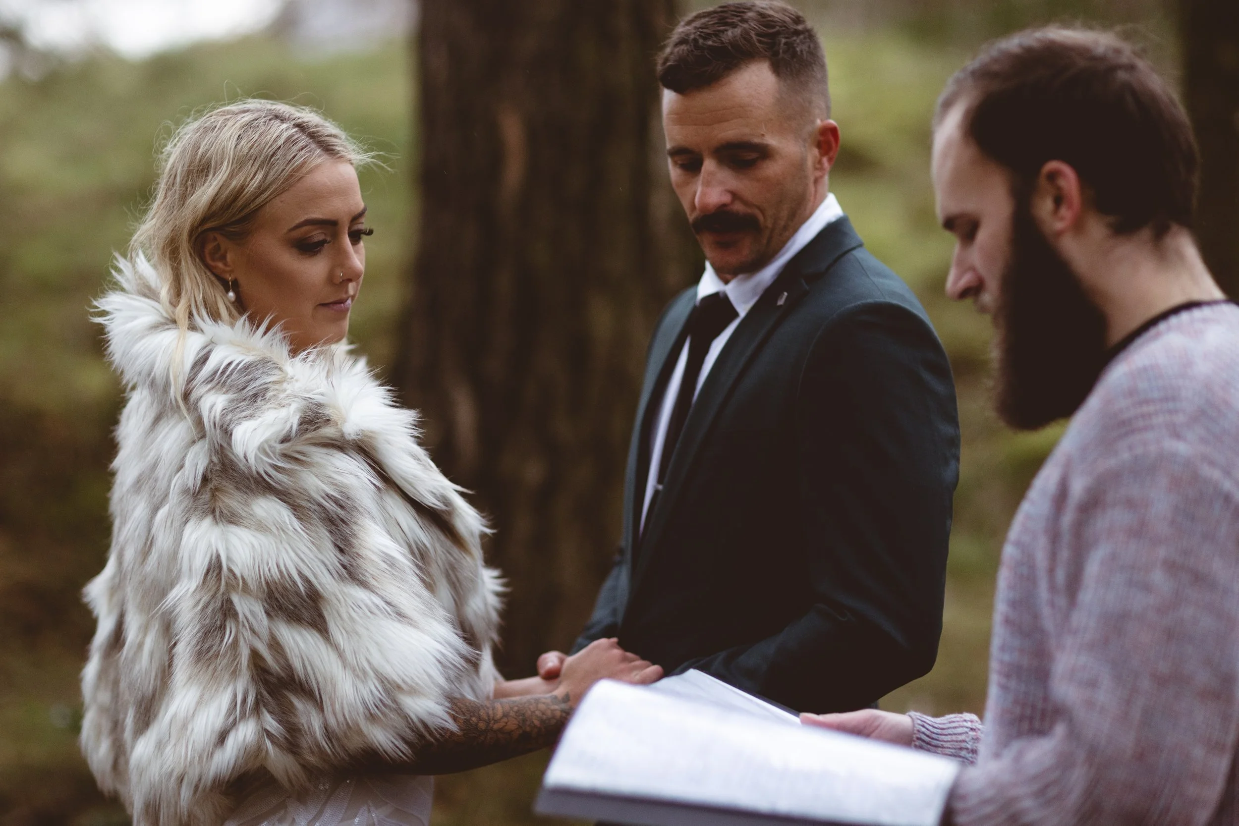 Leon officiating as a couple exchange vows among trees