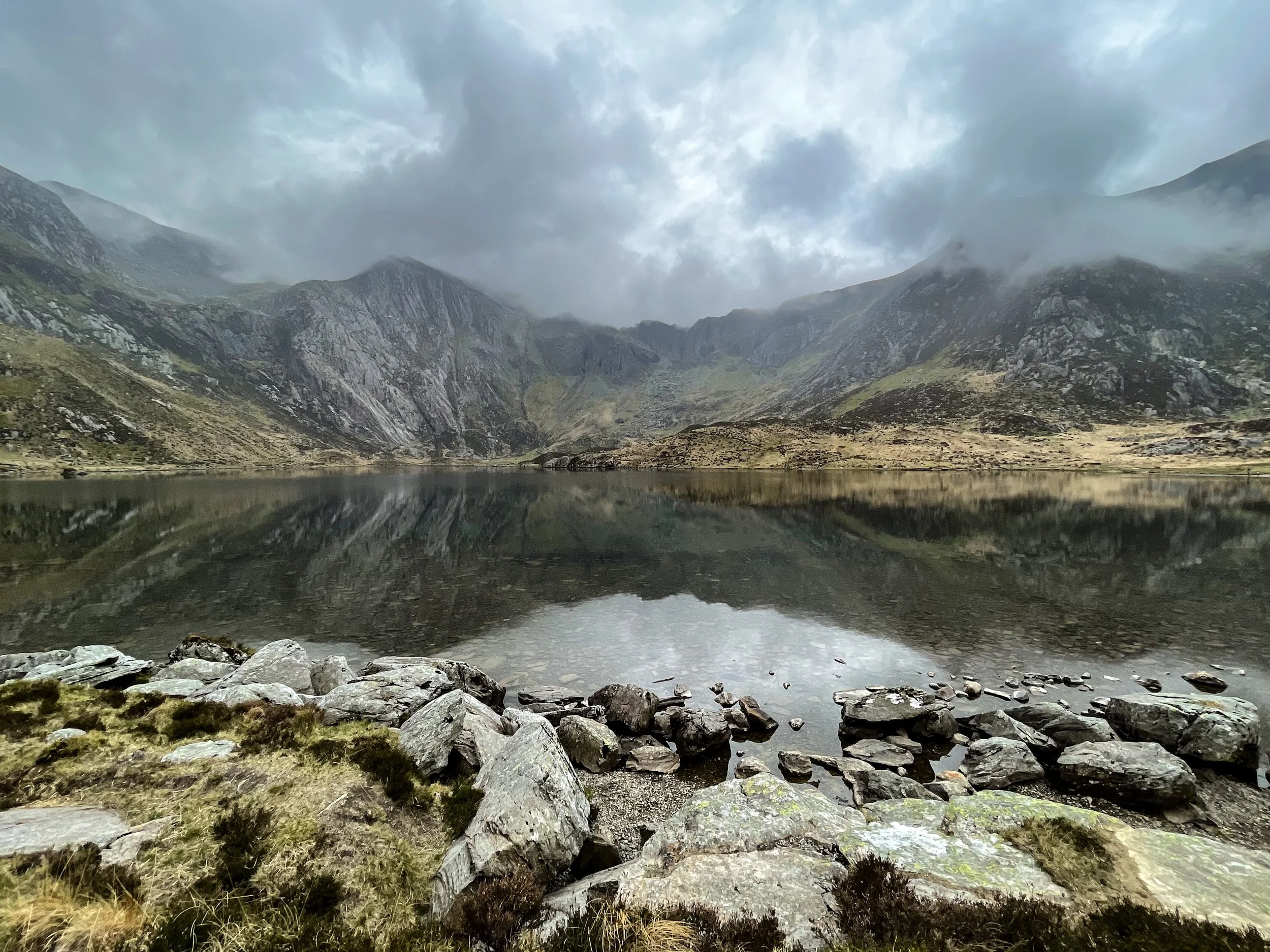 Llyn Idwal reflecting the mountains of Cwm Idwal under low cloud, Eryri