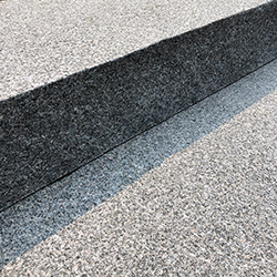 Close-up of two layered, textured stone or concrete steps
