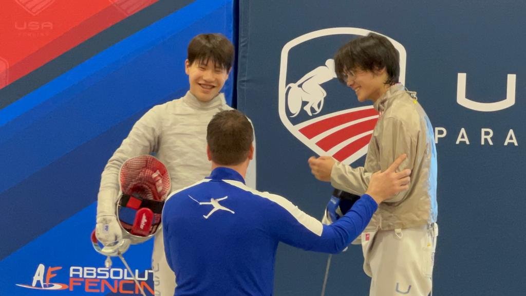 TMFC coach with two fencers at a USA Fencing competition