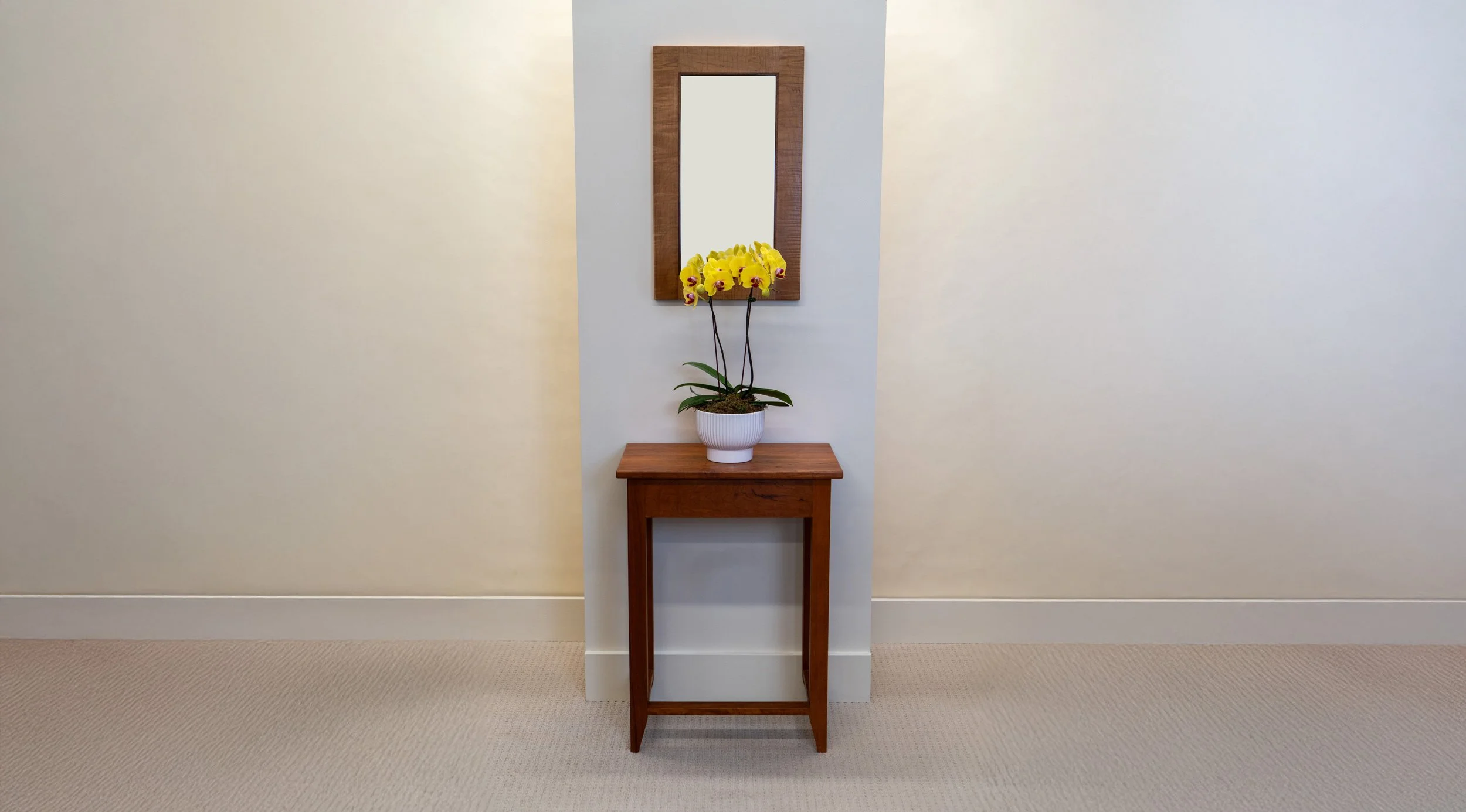 mirror above hall table with potted orchid