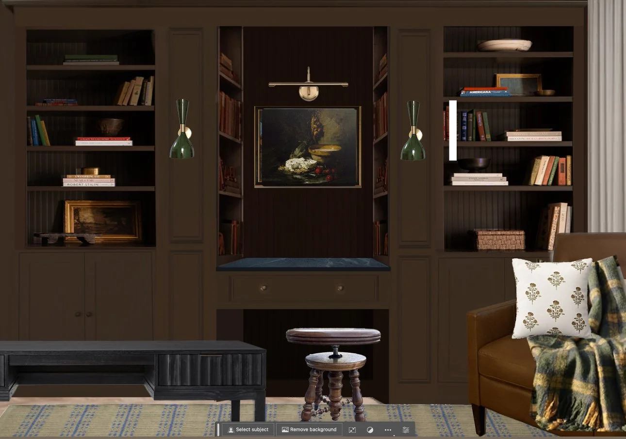 A cozy living room featuring built-in dark wood bookshelves filled with books and decorative items, a painting of a pond scene at the center, a brown leather armchair with patterned pillows, a woven throw, a dark wood coffee table, beige rug with blue accents, and unique green wall sconces.