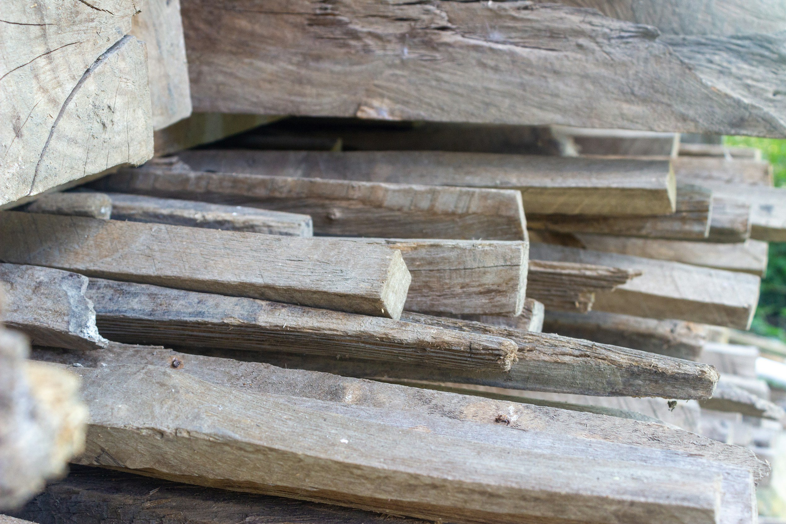 Stacked weathered wooden planks and beams.