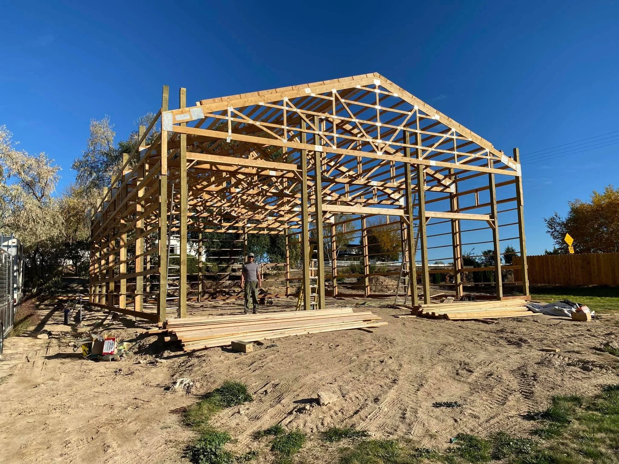 Construction of a wooden building framework outdoors on a sunny day.