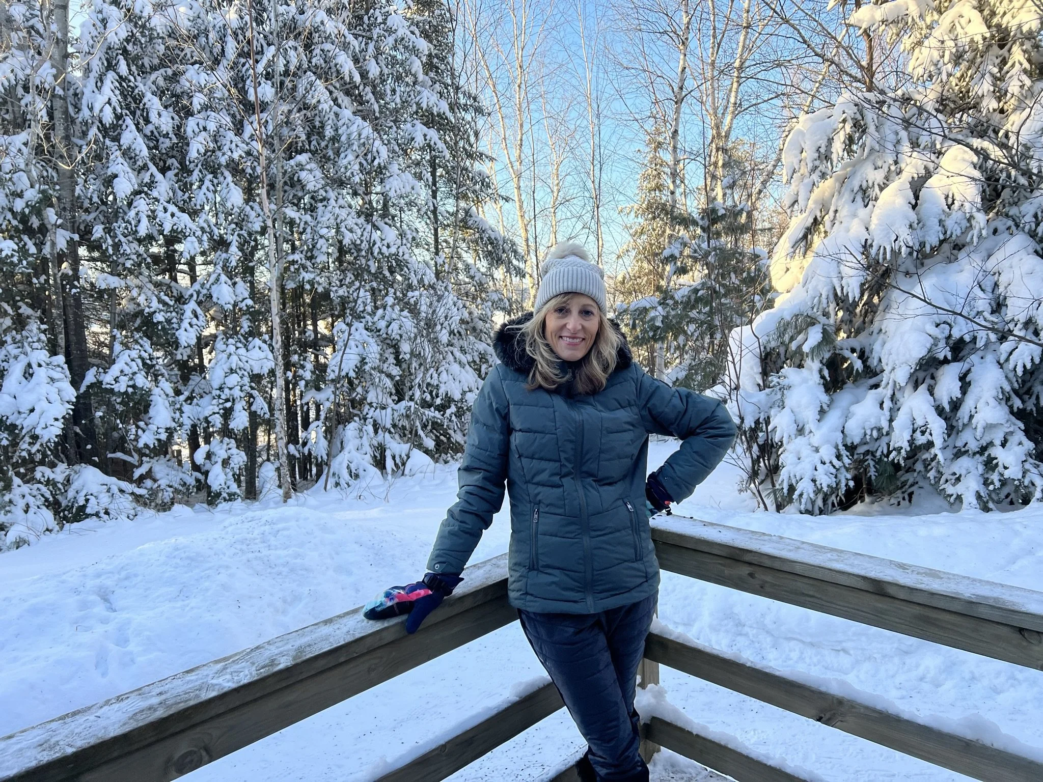 Janell outdoors in the snow with a backdrop of trees