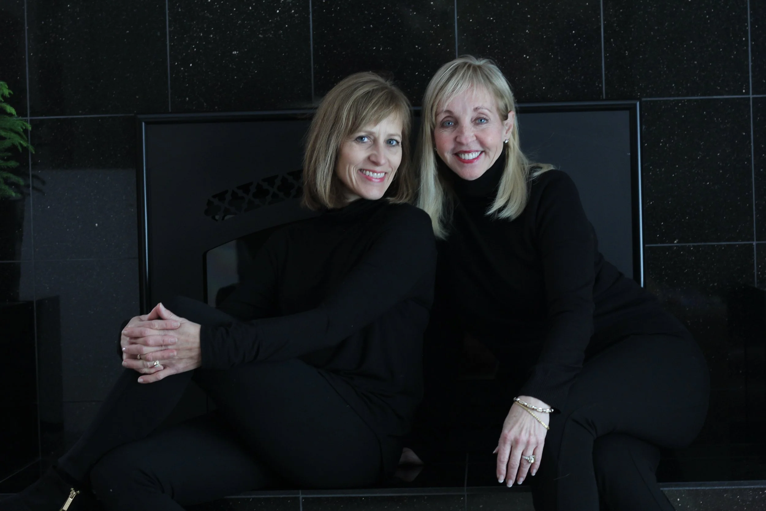 Janell and Barbara in front of a black wall