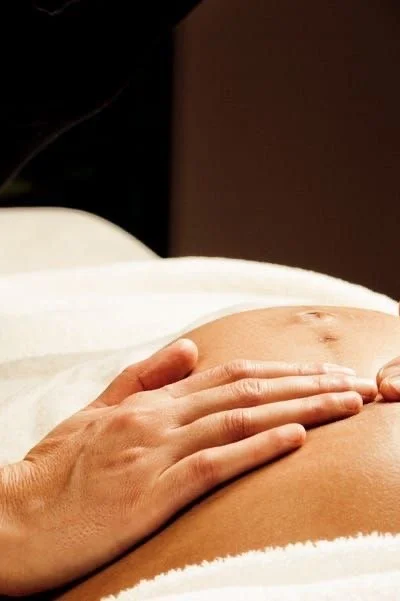 Close-up of a person's belly being gently massaged.