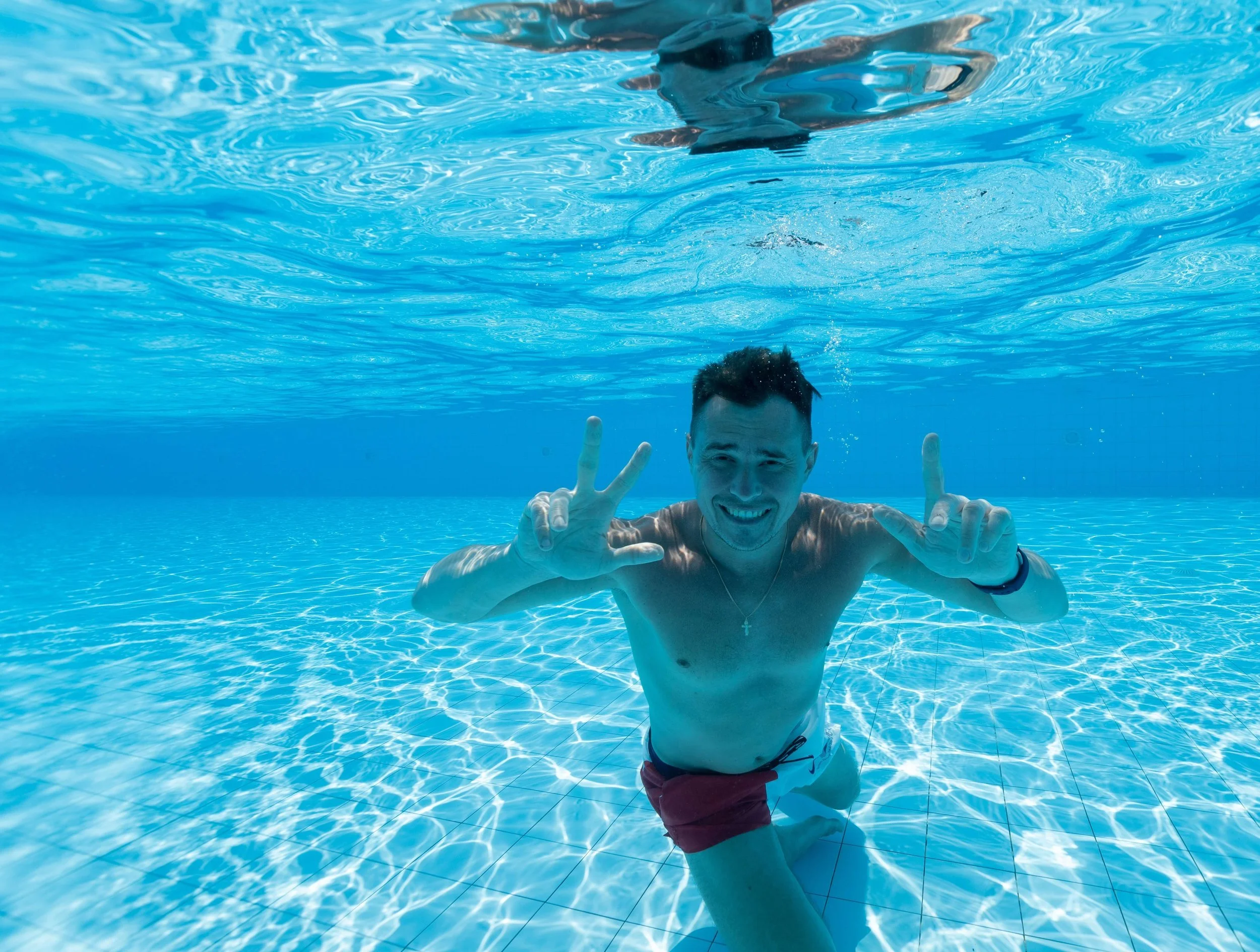 A college student takes time out for self-care by swimming and disconnecting from social media. Learn more tips for surviving the summer months with Therapy for College Students in NYC.