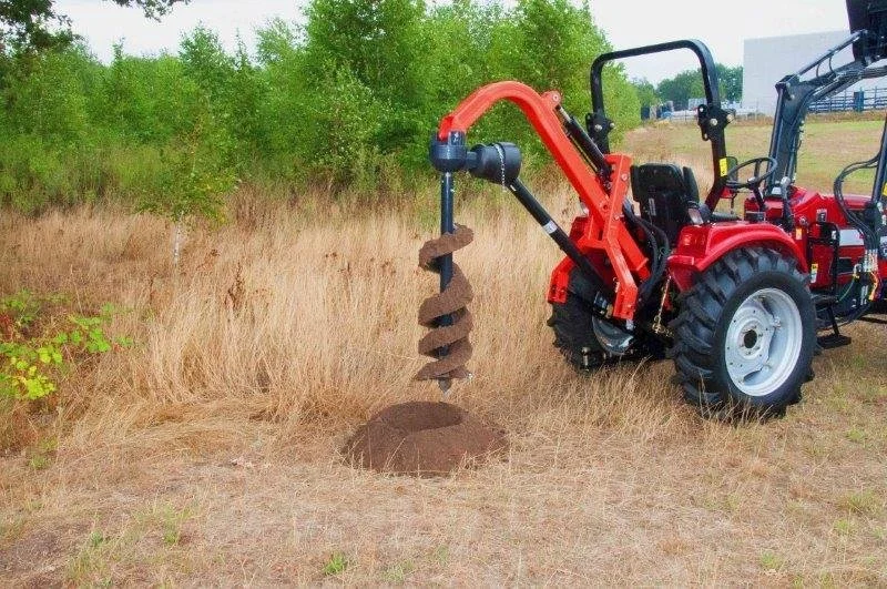 Knegt Tractor, Red tractor equipped with an auger attachment on a grassy field.