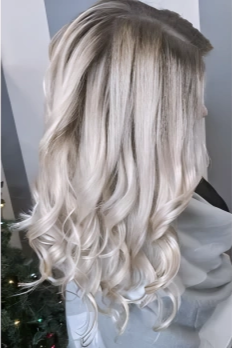 Side view of a woman with long, wavy, platinum blonde hair
