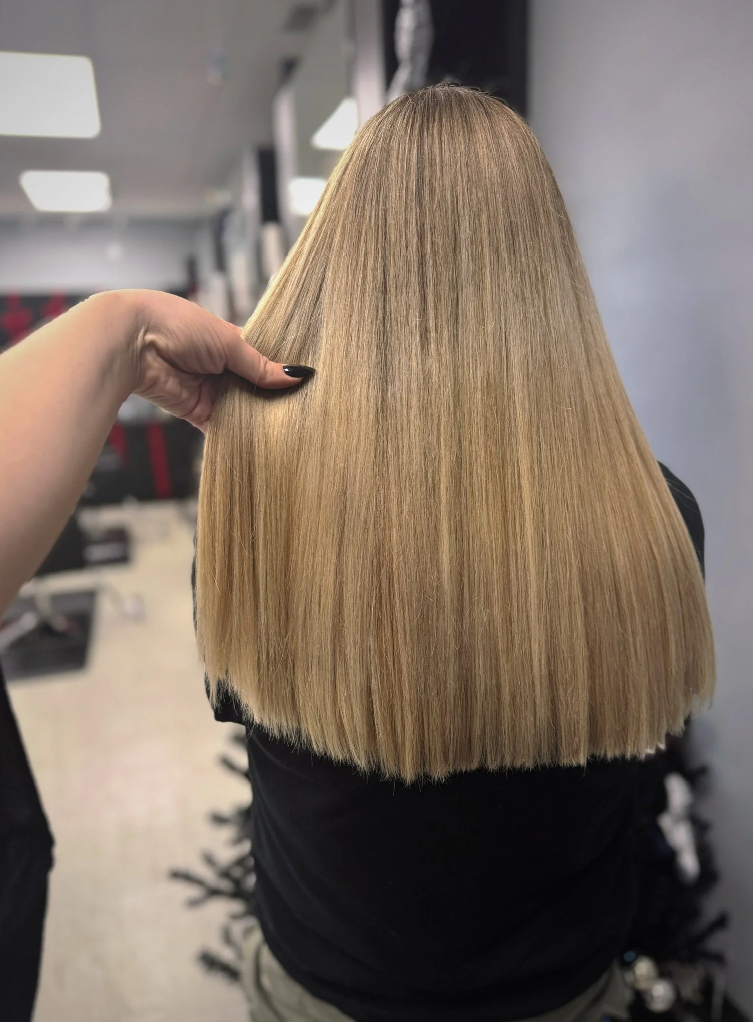 Person with long, straight, blonde hair in a salon.