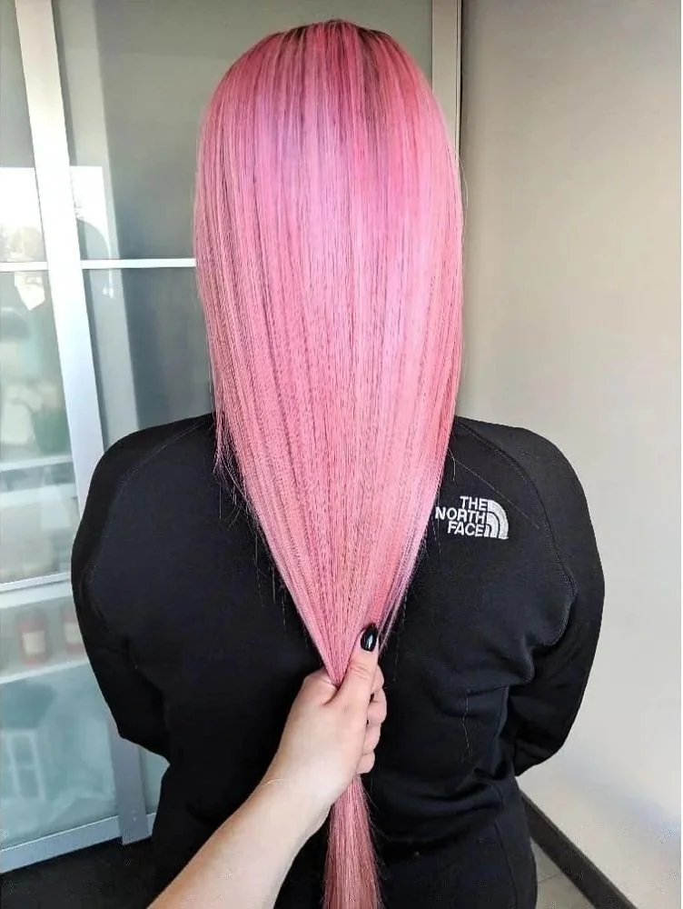 Person with long, straight, pink hair wearing a black North Face jacket.