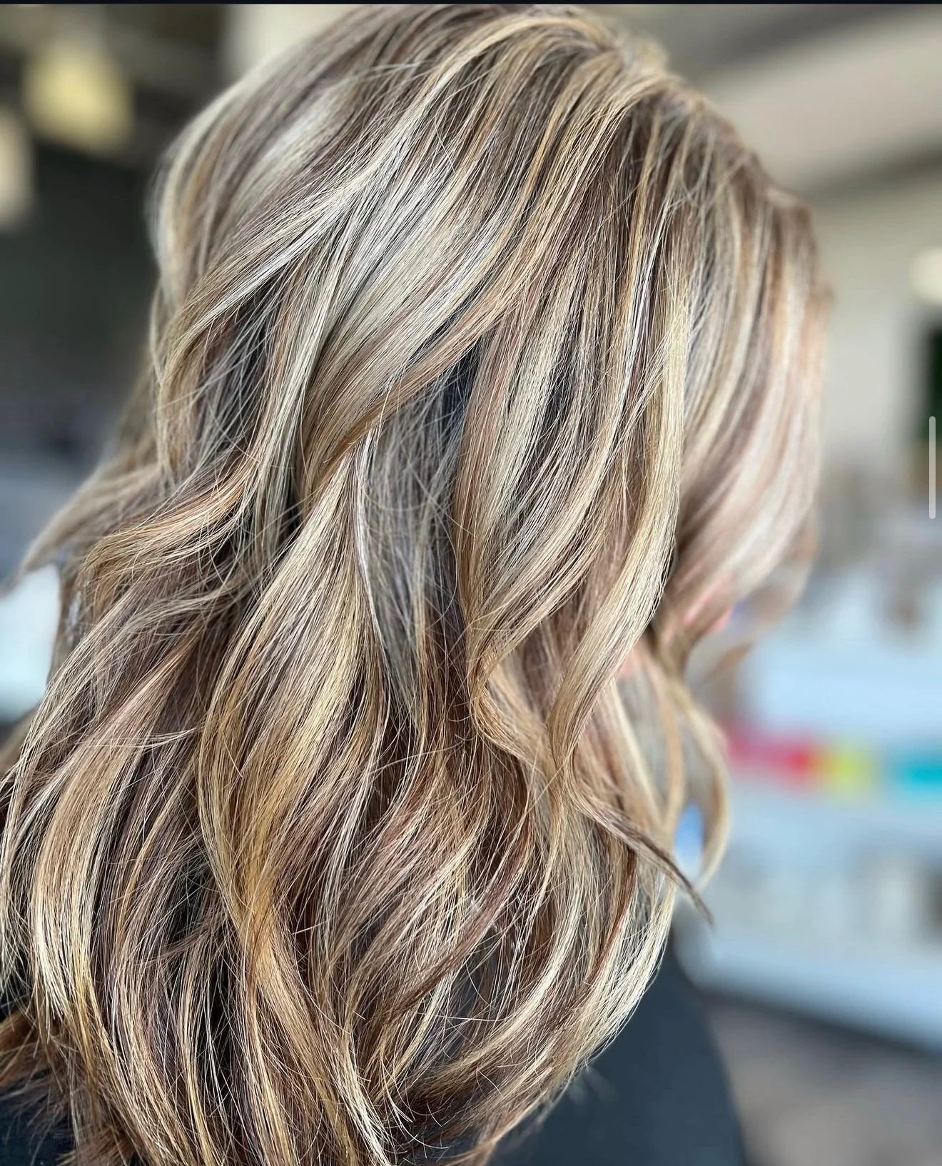 Close-up of a woman's blonde hair styled in loose waves.