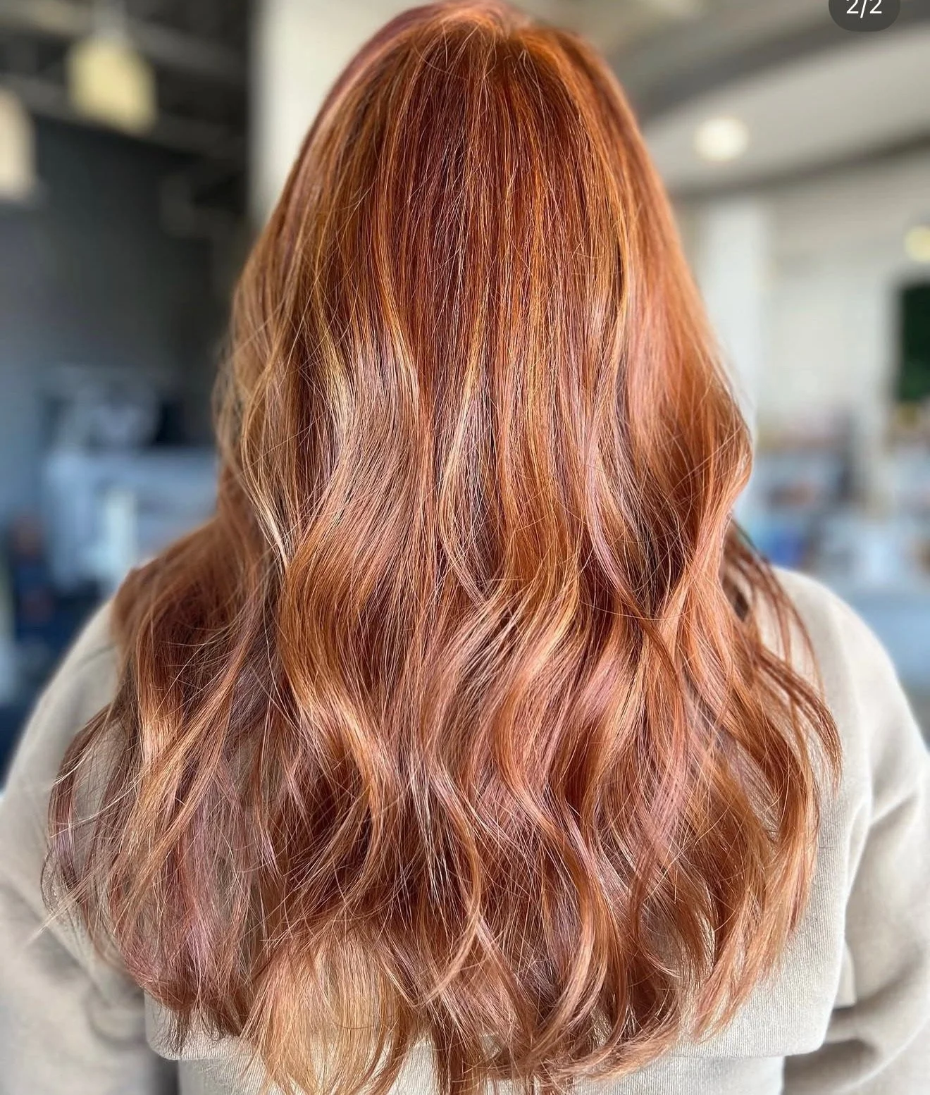 Back of a woman with long, wavy red hair.