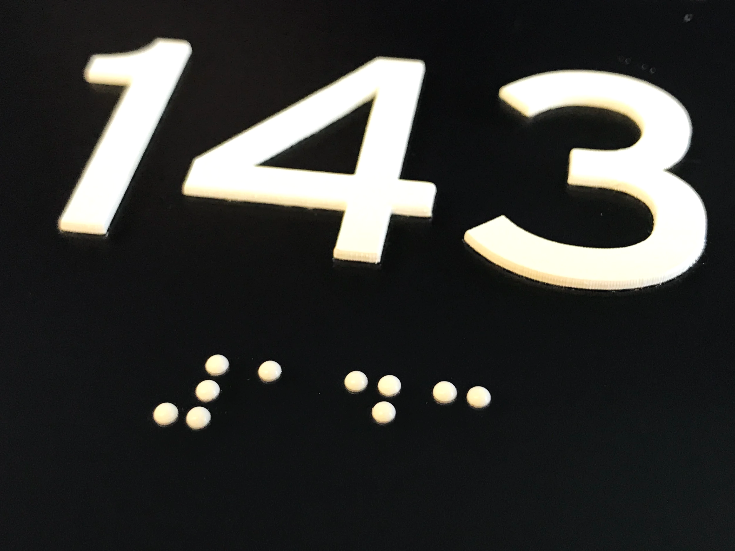 Close up photo of a ADA Braille & Tactile Signage