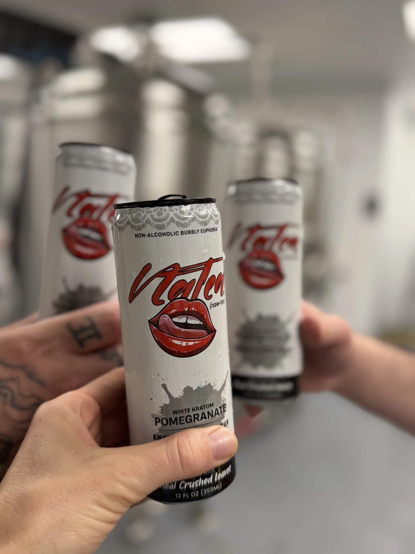 Three Natea botanical tea cans held together at the production facility.